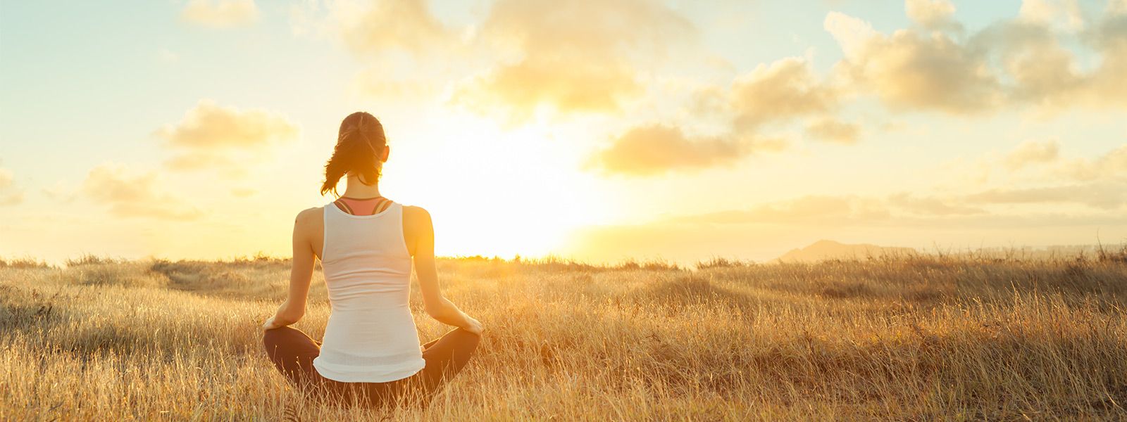 Frau macht Yoga in einem Feld