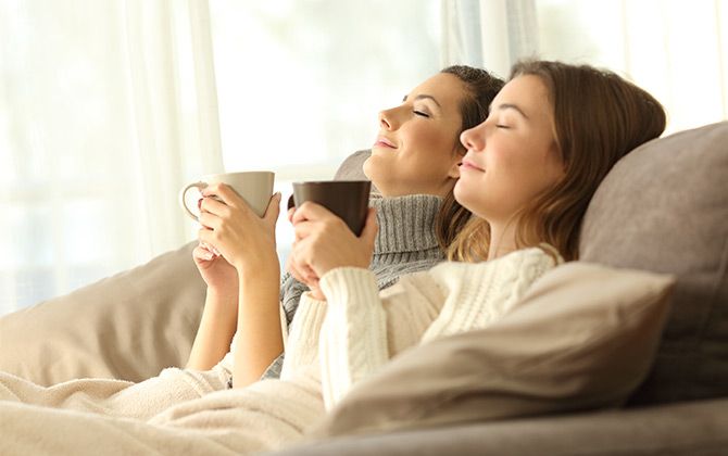 Zwei Frauen in Bademänteln entspannen und trinken Tee