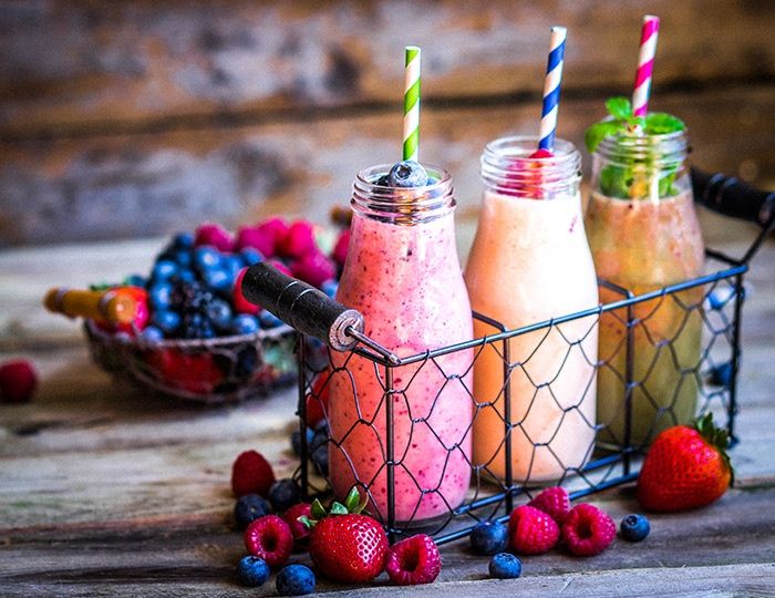 Drei verschiedene Smoothies in Glasflaschen