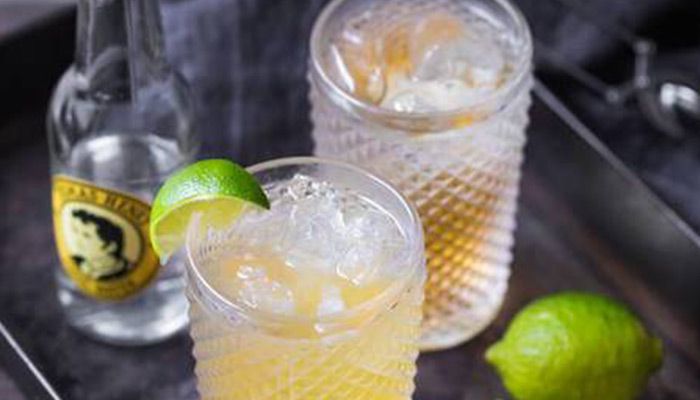 Zwei Gläser mit Eis und Cocktail, daneben Limette