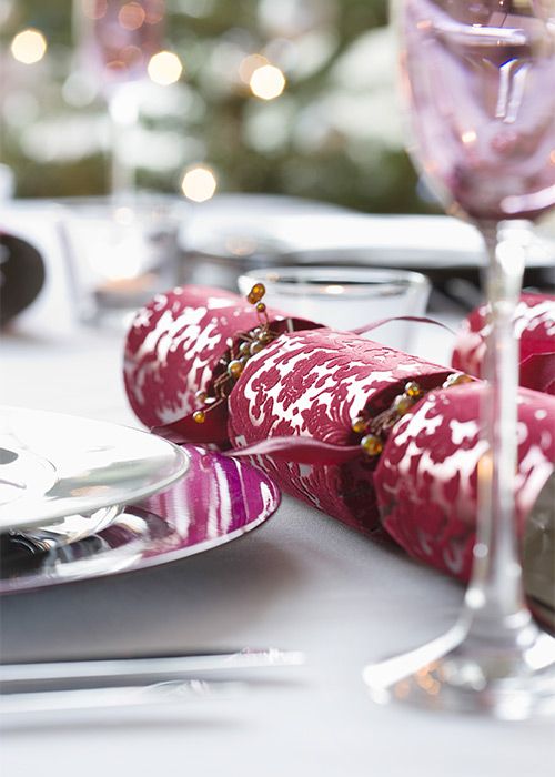 Festlich gedeckter Tisch mit Weihnachtscracker in Rot und Weiß