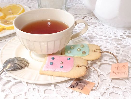 Teetasse und Teller mit Keksen in Form von Teebeuteln