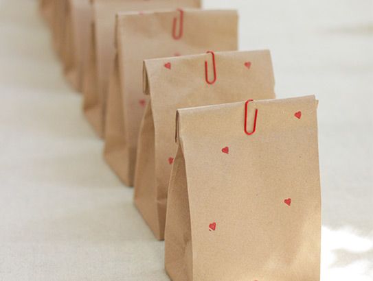 Kleine, braune Tütchen verziert mit roten Herzen und roten Büroklammern