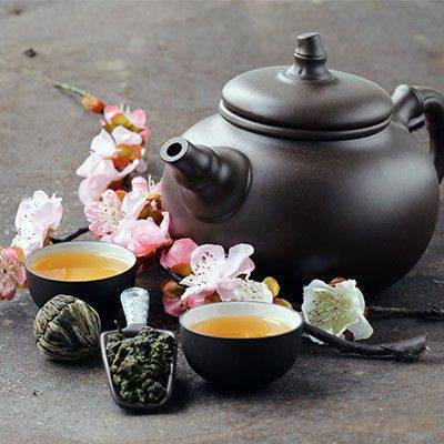 Asiatischen Teetassen und Teekanne mit Blüten