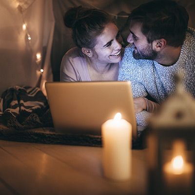 Glückliches Pärchen schaut bei Kerzenlicht einen Film