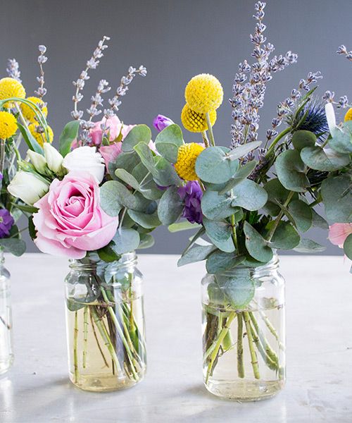 Bunte Blumensträuße in Gläsern