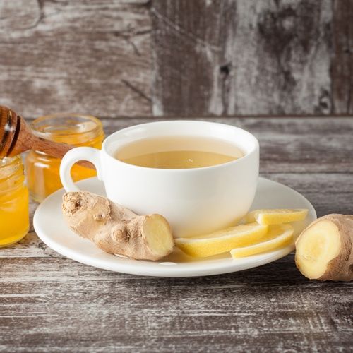 Ingwer-Tee in einer Porzellan Tasse von Ronnefeldt aufgebrüht und mit frischem Ingwer versehen